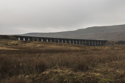 Bridge on field against sky