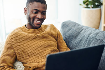 Portrait of smiling young man using mobile phone