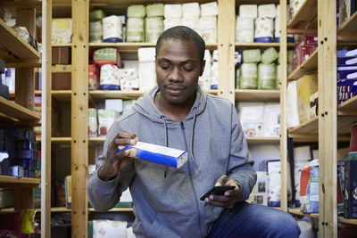 Mid adult worker examining product in warehouse