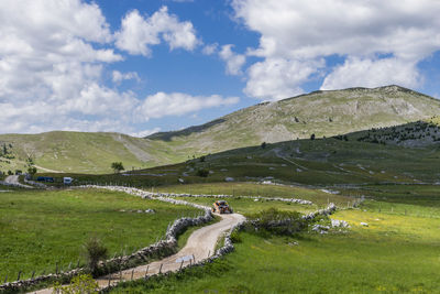 Scenic view of green landscape against sky