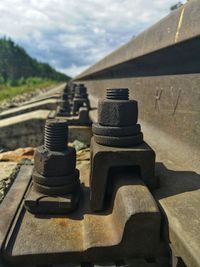 Close-up of railroad track against cloudy sky