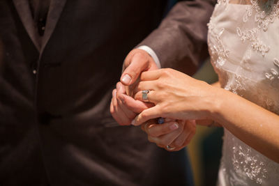 Midsection of couple holding hands