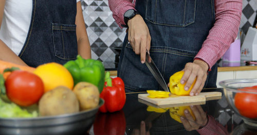 Midsection of woman holding fruits at home