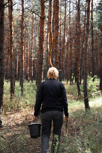 Rear view of woman walking in forest