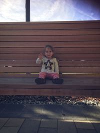Portrait of smiling girl sitting on bench 