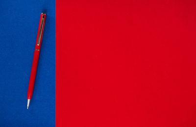 Close-up of  pen against red background