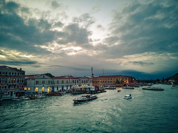 View of buildings at waterfront against cloudy sky