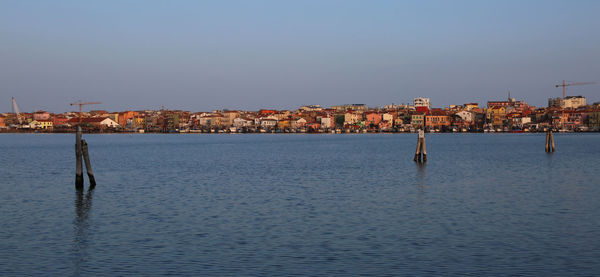 Scenic view of sea by town against sky