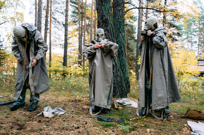 Rear view of people standing in forest