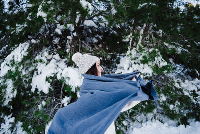 Woman wrapped in blanket in snowy mountain. winter