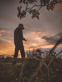 Full length of man standing against sky during sunset