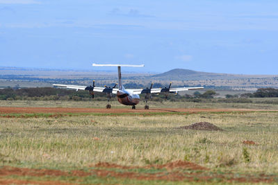 Airplane on field against sky