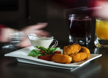 Chicken nuggets and ketchup sauce in white pate on table