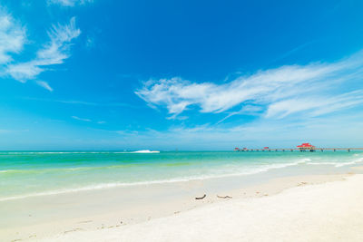 Scenic view of beach against blue sky