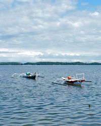 Boat sailing in sea against sky