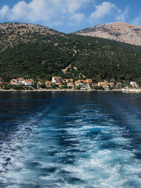 Scenic view of sea by buildings against sky