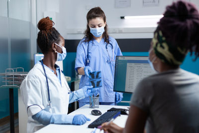 Doctor wearing mask talking with nurse at hospital