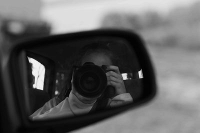 Close-up of man photographing through camera