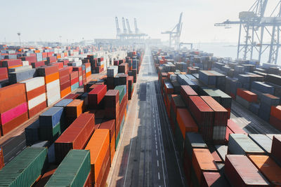 From above perspective view of various colorful containers stacked on deck of freighter in daylight in harbor of valencia