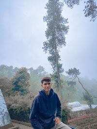 Young man standing on mountain against sky