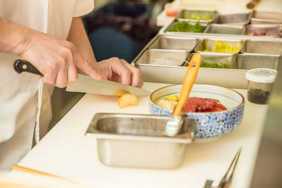 Midsection of man preparing food in kitchen at home