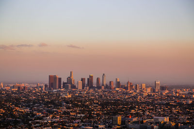 Modern buildings against sky during sunset in city