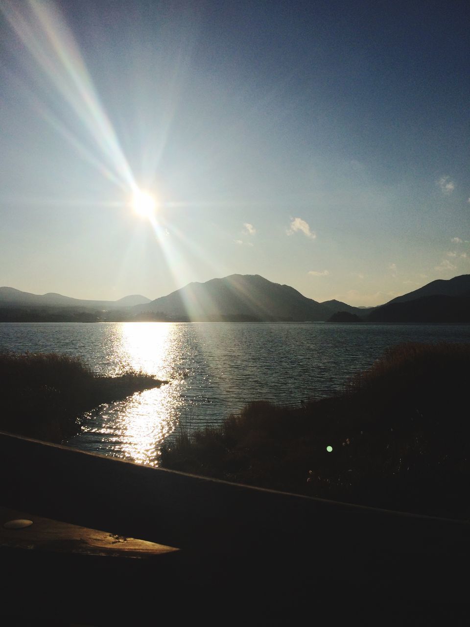 water, sun, tranquil scene, scenics, sky, reflection, tranquility, sunlight, sea, sunbeam, beauty in nature, sunset, lens flare, nature, lake, silhouette, idyllic, rippled, mountain, outdoors