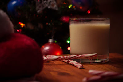 Close-up of drink by candy canes in glass on table