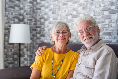 Portrait of smiling friends standing against wall
