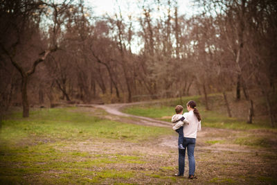 Rear view of couple standing in forest