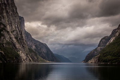 Scenic view of fjord and mountains against sky