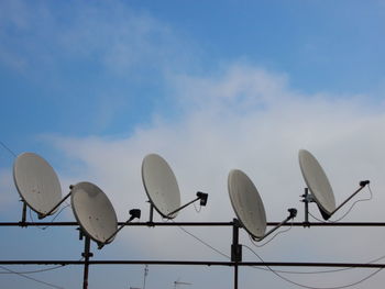 Low angle view of satellite dishes against sky