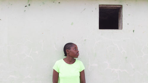 Young man standing against wall