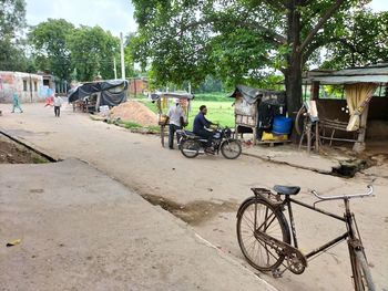 Bicycle on road against trees in city