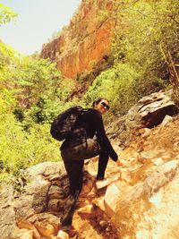 Man standing on rock against trees