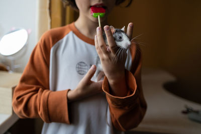 Midsection of woman holding thermometer