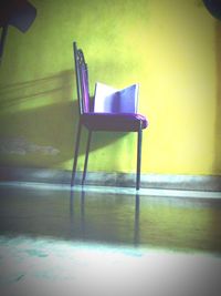 Empty chair and table against wall at home