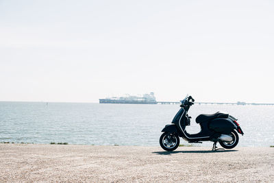 Scenic view of a scooter standing in front of the sea against clear sky