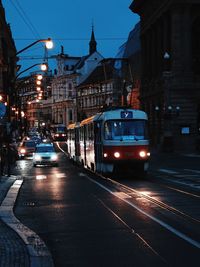 Cars on illuminated street in city at night