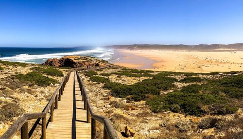 Scenic view of beach against clear blue sky