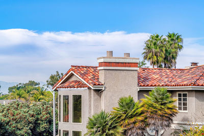 House and palm trees against sky