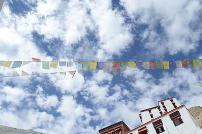 Low angle view of flags against cloudy sky