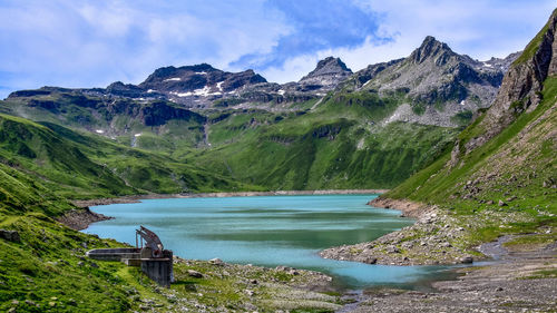 Scenic view of lake by mountains against sky