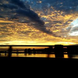 Scenic view of dramatic sky over river during sunset