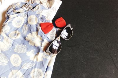 High angle view of sunglasses with clothes on table