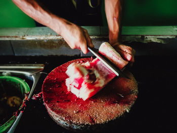 A vendor cut up the fish in the fish market manual cleaning of seafood with a scissors. malaysia.