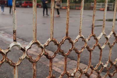 Close-up of rusty metallic fence in city