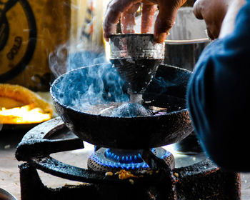 Midsection of man preparing food in wok