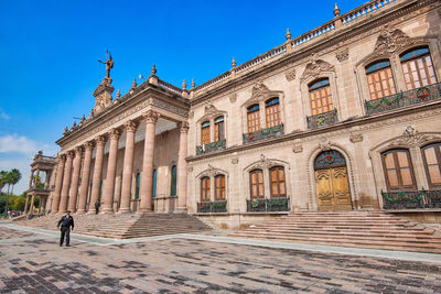 People walking in front of historic building