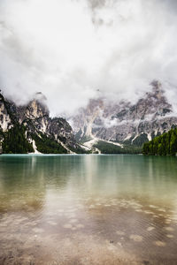 Scenic view of lake by mountains against sky